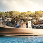 Sleek luxury yacht cruising near rocky coastline
