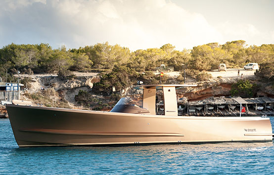 Sleek luxury yacht cruising near rocky coastline