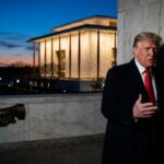 Man in suit near Lincoln Memorial at dusk
