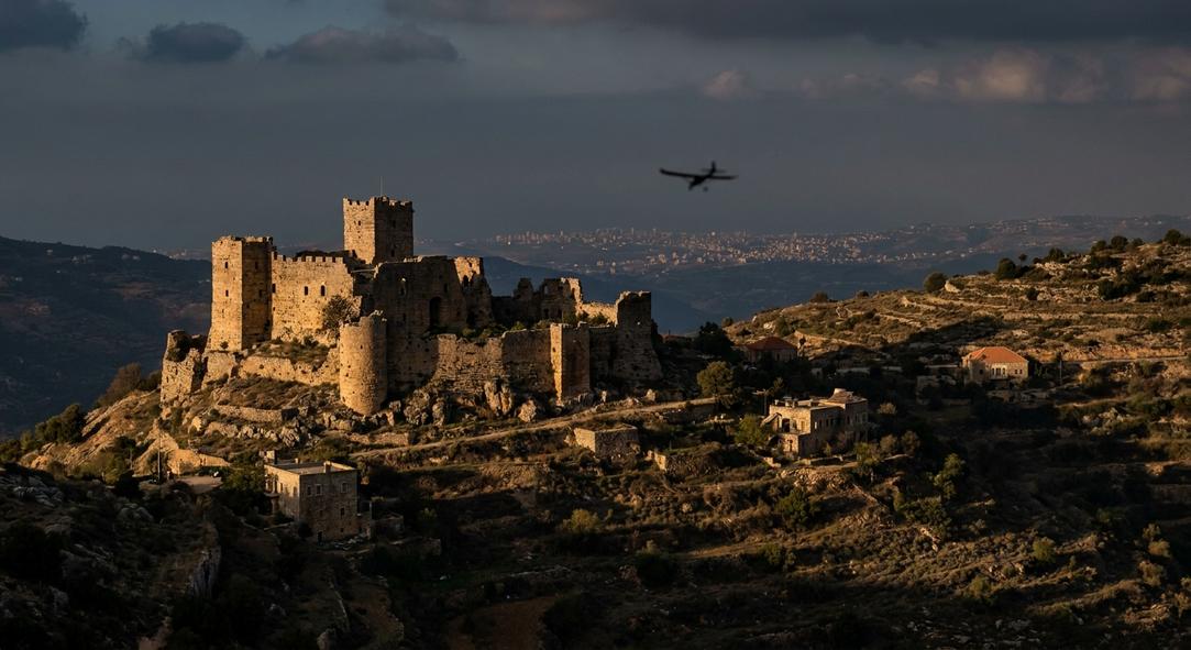 Ancient stone castle on hill at sunset
